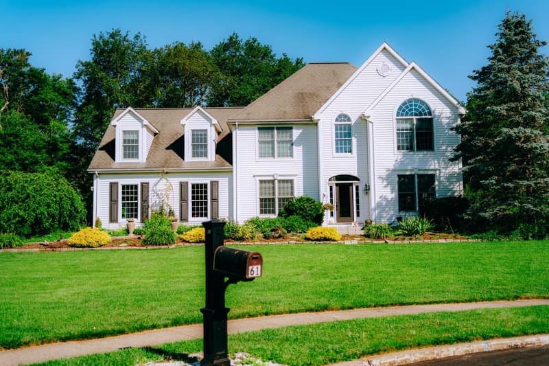 Suburban house with a green lawn and a mailbox at the curb