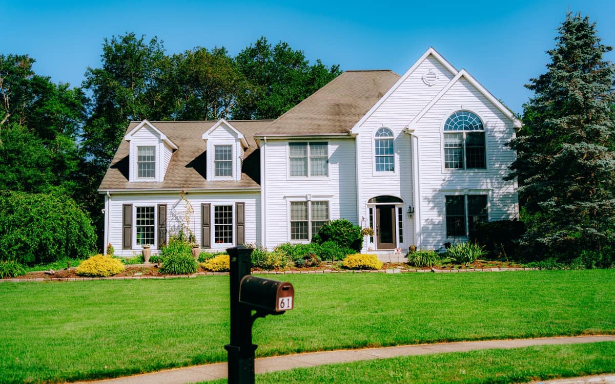 Suburban house with a green lawn and a mailbox at the curb