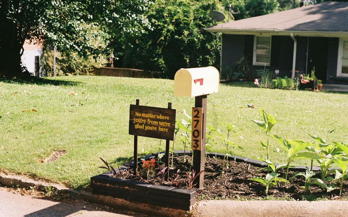 Suburban front yard with a mailbox and plants on a sunny day