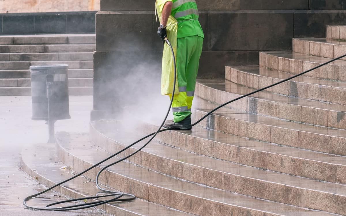 Worker pressure washing outdoor steps