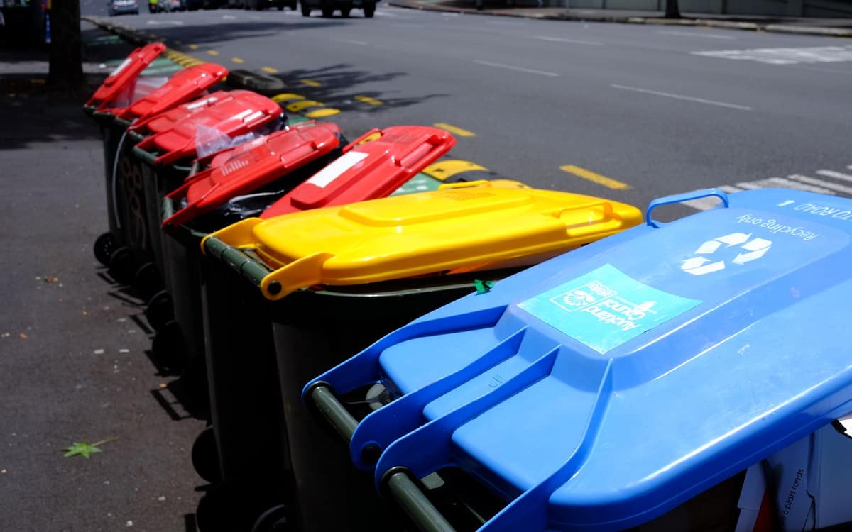 Colorful recycling bins lined up on a sunny street
